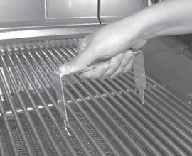 To install the warming rack, lift the front of the rack up slightly and insert the rack hangers into the two holes in the back of the inner oven hood.
