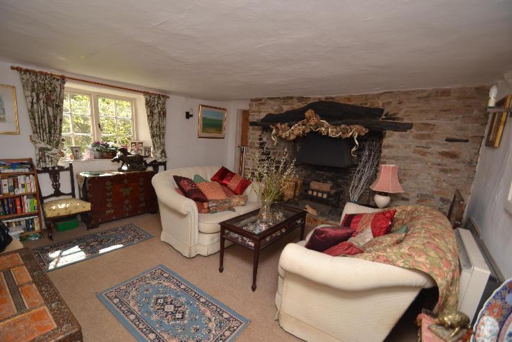 The spacious cottage is situated in its own grounds with a gated entrance and opens onto the pathway up to the cottage with stone and cob walls and thatched roof with slated entrance porch.