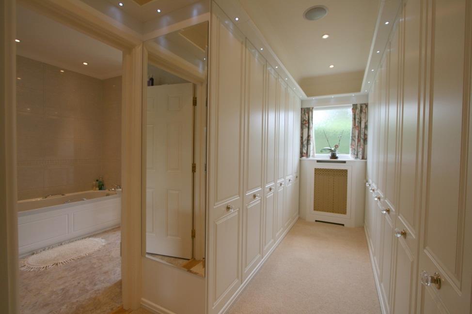 Door to: Bathroom White suite comprising bath, bidet, wc shower and wash basin set into a high gloss vanity unit with drawers below and large mirror over. Matching vanity cabinet.