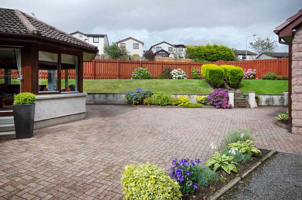 The large fully enclosed garden is beautifully maintained and thoughtfully landscaped to include extensive loc-bloc patio areas, shaped lawns, well stocked flowerbeds and borders housing a colourful