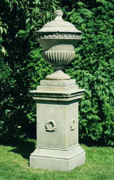 The Lidded Finial Urn [item 46] An elegant lidded urn having circular socle and square base. The campana shaped body having lobed decoration to the bowl with medallions to the rim.