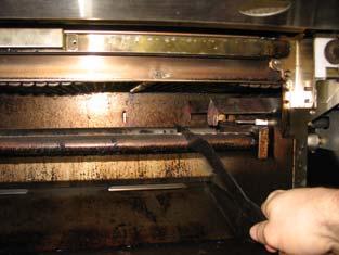 Clean the top of the burner with the brush end of