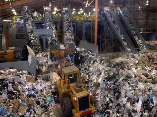 Mixed recycling is loaded onto conveyor lines which