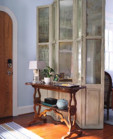 Right A narrow table is a graceful drop zone. Mirrored panels on the folding screen in the entry reflect light from the windows. Below The exterior's original Tudor styling was refreshed.