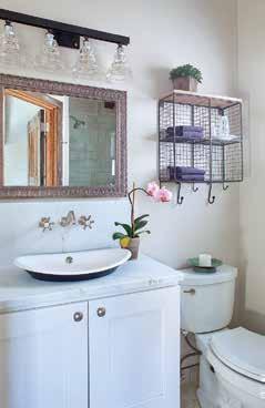 A vanity light from Troy Lighting, metallic mirror from Pier One and curved basin-style Kohler sink add elegance to the bathroom.