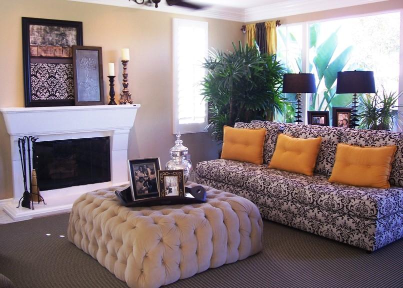 The pattern of the couch gives it visual weight, so that it is to scale with the large ottoman. A group of objects above a fireplace also helps to create scale.