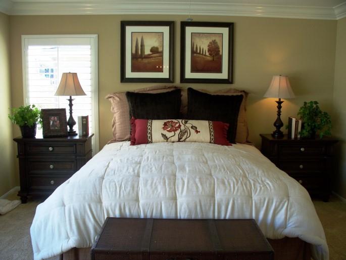 The bedroom in the same home displays symmetry, which promotes a sense of peace and sanctuary needed in a bedroom; and rhythm (the red accents are continued).