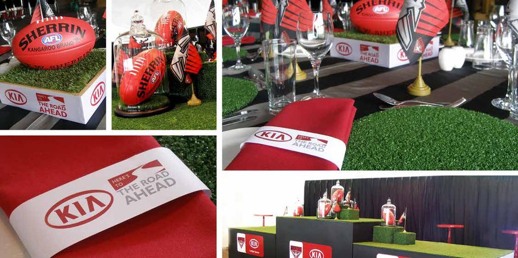 FOOTBALL - KIA Custom black carpet with white broken lines to represent a road. CENTREPIECES: Timber box with custom designed and printed trim filled with synthetic turf insert and Sherrin football.
