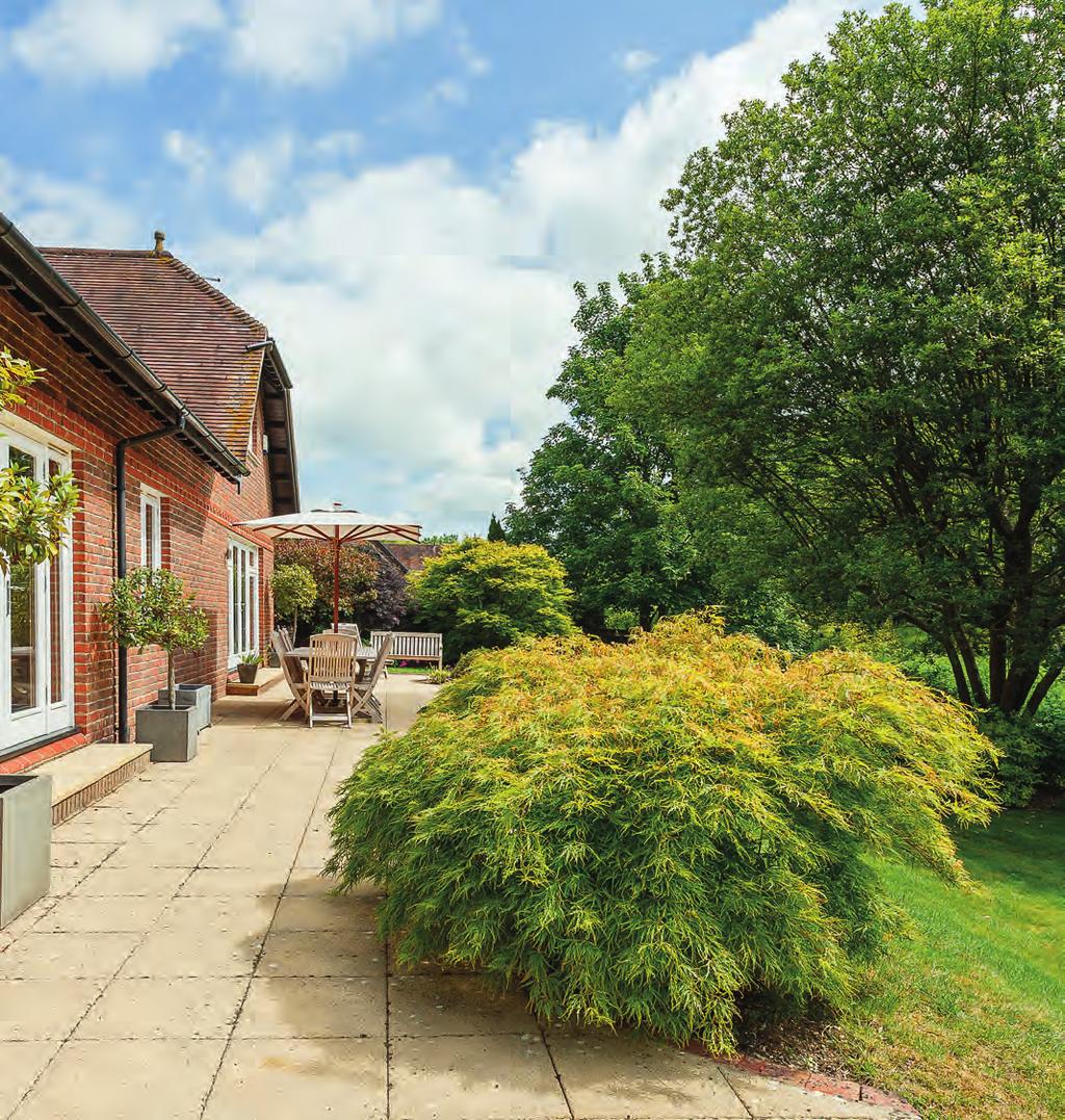 Outside, the grounds are immaculately maintained with established planting, mature