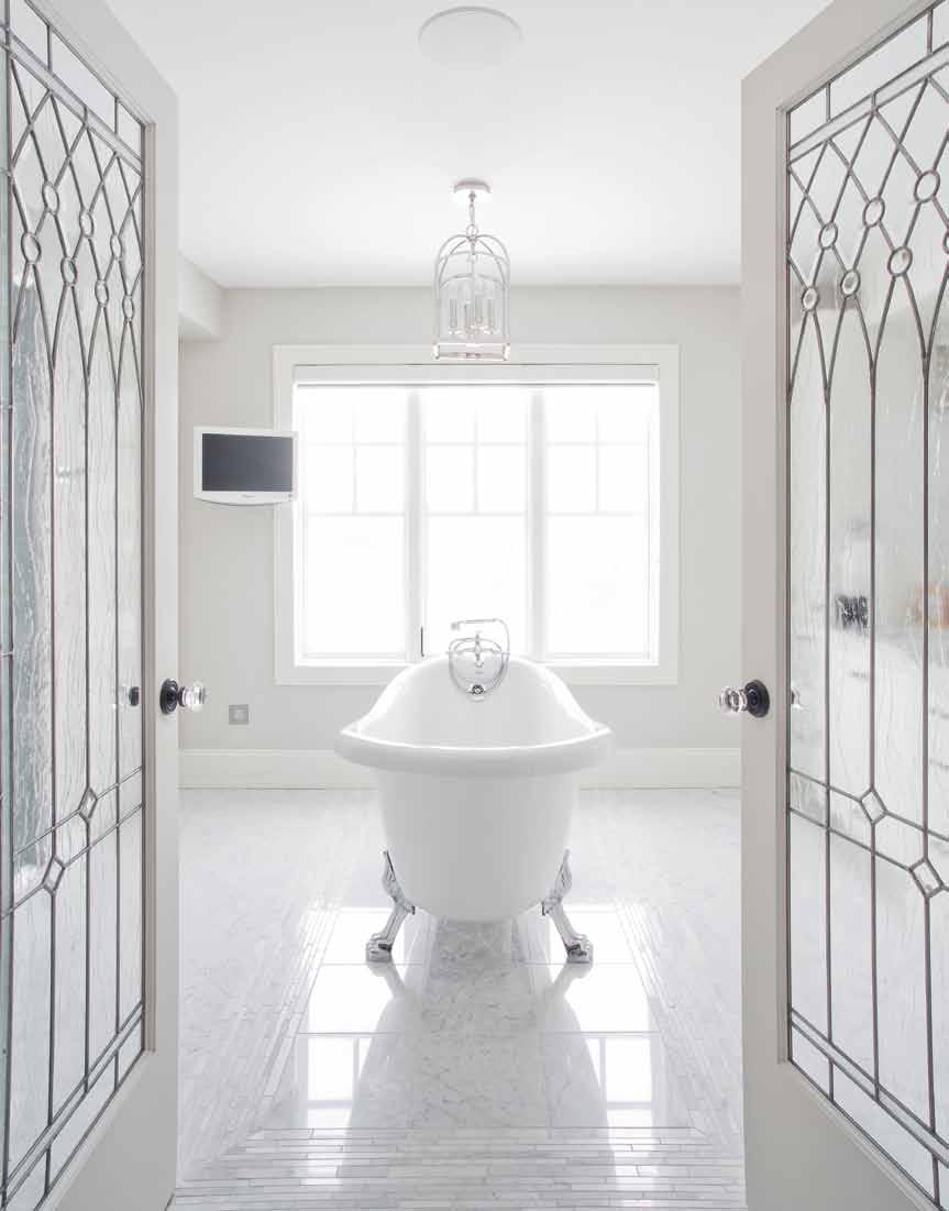 The bright, airy bathroom also boasts sharp white cabinetry and is made even more striking with a claw-foot tub and marble flooring, which the homeowners sought