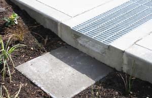 Trench drain systems are designed to convey stormwater runoff within a shallow channel while maintaining unimpeded pedestrian or vehicular access.