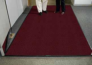 The backing material is not specified by LEED. Triple S recommends rubber backed mats. The use of vinyl is highly controversial in the green community due to disposal issues.