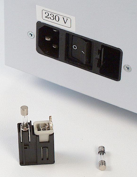 Use a small flat screwdriver to pry the voltage selector/fuse block assembly away from the power entry port housing and remove (Fig. 7.1). Fig. 7.1 Opening the voltage selector/fuse block assembly 3.