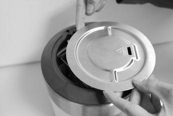 2 Lift out the screw driver and insert your finger in the recess () at the top of the measuring cell and lift off the lid (2) with two hands.