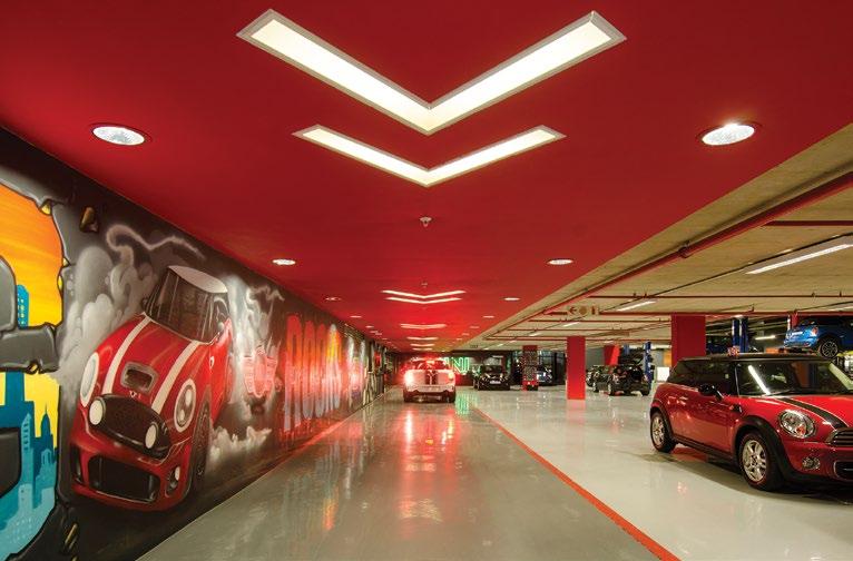 The active service reception lane is demarcated by a red runway ceiling above the lane An exclusive MINI merchandise shop is also located within the showroom,.