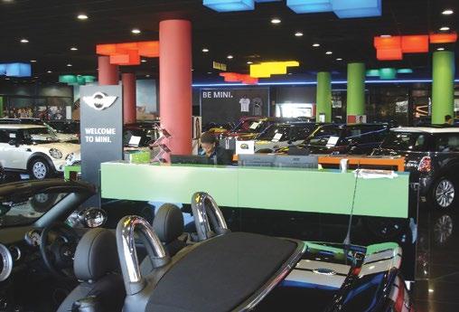 A MINI replica car is suspended from the ceiling slab above the hand-over bay in a dealership to create a unique experience for each customer who visits the dealership.