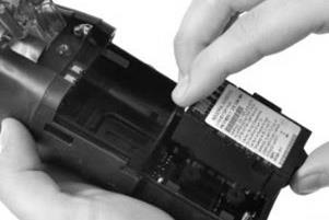 Install a compatible extended-run-time battery label side up into the lower