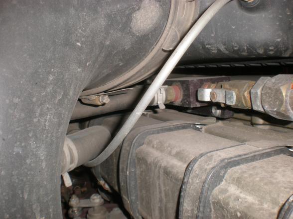 The thermostat is an inlet type and its housing connects to the lower radiator hose. Leave the plug out until instructed otherwise. The red arrow points to the drain plug 9.