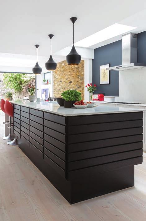 The simple, yet elegant aim for this space was achieved through the use of black-finished cabinetry and dining chairs, dark painted walls and slick, white, tall cabinetry and worktops.
