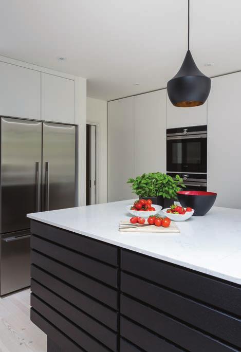 The Barazza 1PLB5 hob is flush-fitted into the worktop of the far cabinetry, and is paired with a Bosch WB09W452B extractor hood, both of which boast a sleek stainless steel aesthetic.