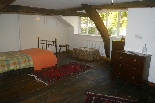 Double room with original cast iron fire surround. Exposed beams and floorboards with alcove shelving and attractive views over the front garden towards Brathay River and Wansfell Pike.