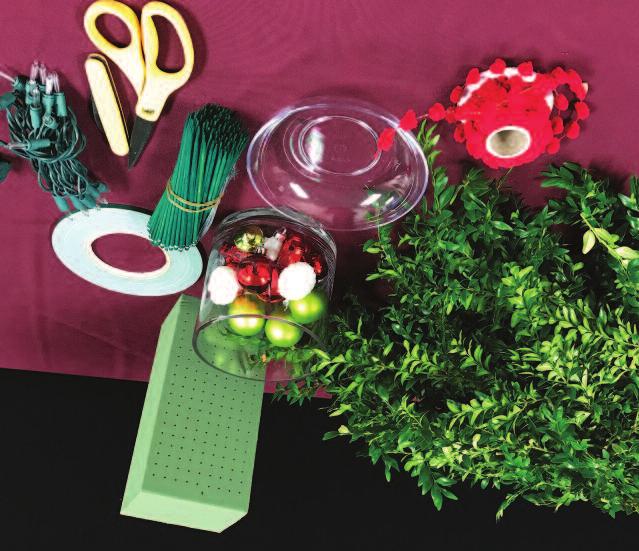 MATERIALS 1 2 lb fresh-cut boxwood Fresh flower foam Waterproof tape Wired wood picks Floral shears Knife Floral container Holiday trimmings (pinecones, ribbon, garland, electric or battery-operated