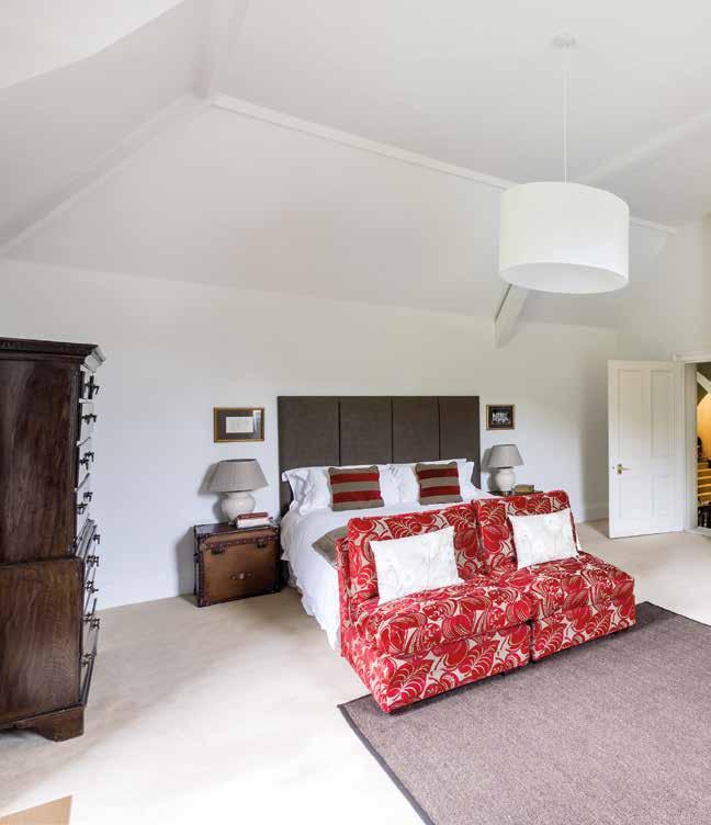 relaxed style of bedroom with vaulted ceiling, exposed brickwork and beams.