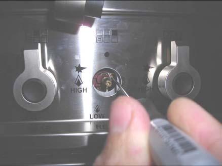 With a slotted screwdriver turn the choking screw (by pass screw at the left side of the thermostat bar) and, while observing the flame at the same time through the bottom oven porthole, evaluate the