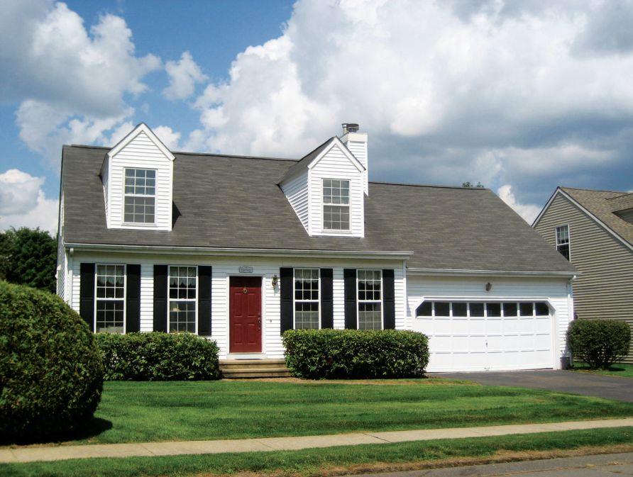 [REGIONAL DESIGN] Except for the attached garage, this Cape Cod is a good representation of the original style: an economically designed house that tucks extra square footage into dormers.