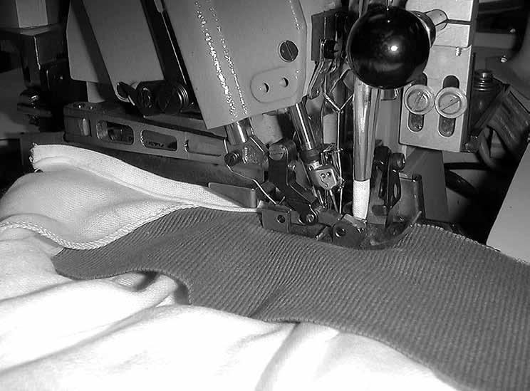 Topstitching the tape and hanging the label in a separate operation produces a flat, uniform collar seam and gives a two-needle taping look to the finished garment.