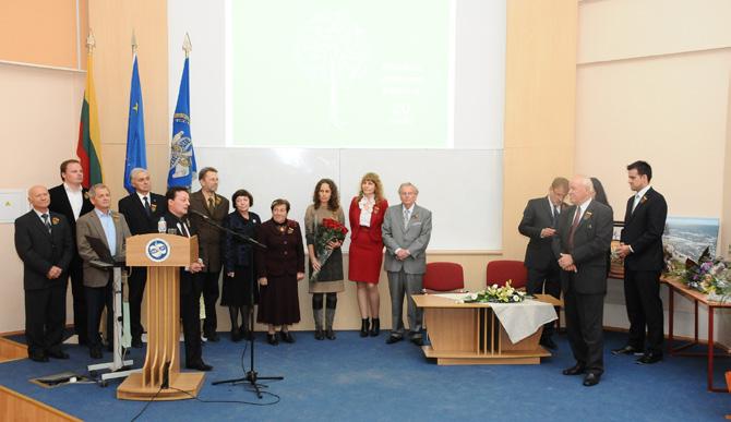 2013 m. rugsėjis Aplinkos apsaugos katedros 20-mečio šventėje katedrą įkūrusį prof. P. Baltrėną (priekyje iš dešinės) sveikina kolegos. Prie mikrofono prof. D.