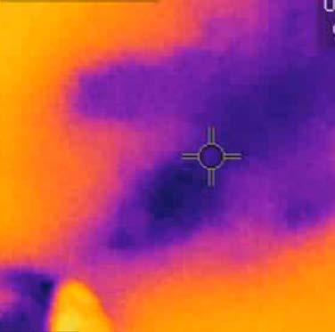 Inside the one story building, the inspector examined the ceiling. The inspector scanned the surface of the ceiling with the thermal imaging camera.