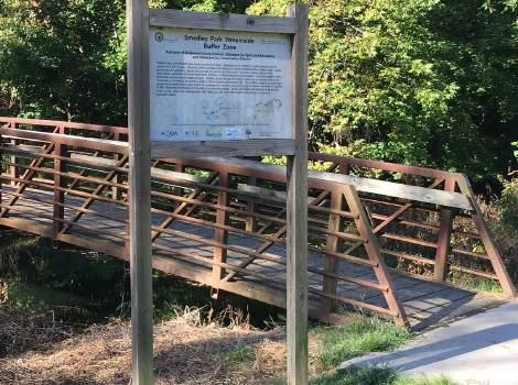Interpretive signage (bottom right) is placed strategically in front of a bridge crossing Crum Creek to