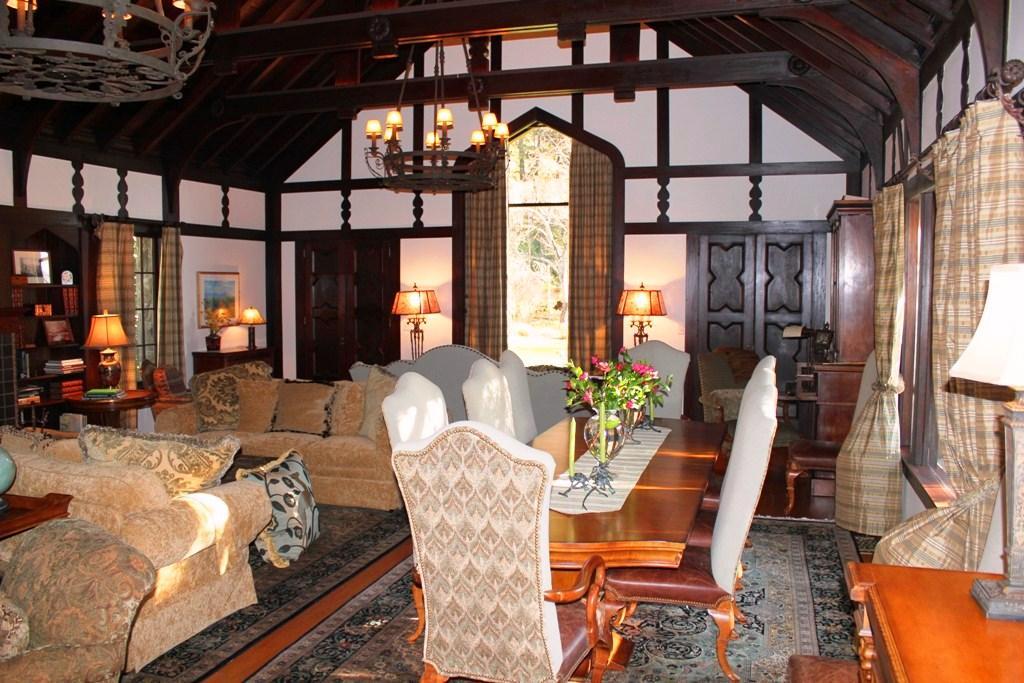 The manor style great room with exposed clear redwood beamed cathedral ceilings, wood burning fireplace and original
