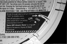 On back side of alarm, locate the area on product label. Break through label with a screw driver. Slide the tab to the OFF location.