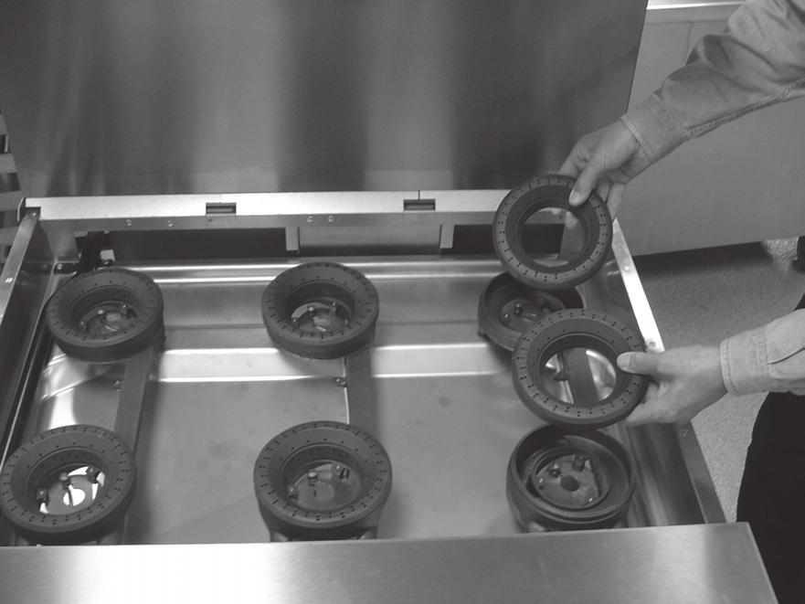 After cooling, remove the top rings from the burner heads (Fig. 14).