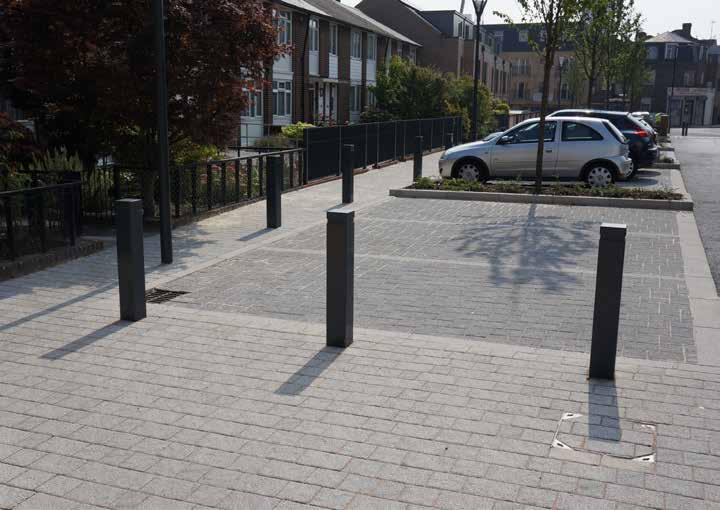 with silver grey for pedestrian areas and charcoal for parking, alongside a new tarmac carriageway.