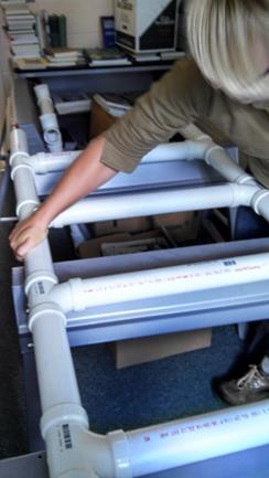 On a flat surface, fit the sections of PVC pipe and connectors together into a rectangular frame with 6 cross pieces.