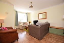5") A lovely reception room situated to the front aspect of the property with a double glazed bay window, laminate flooring, understairs storage cupboard, central heating radiator and coving to the