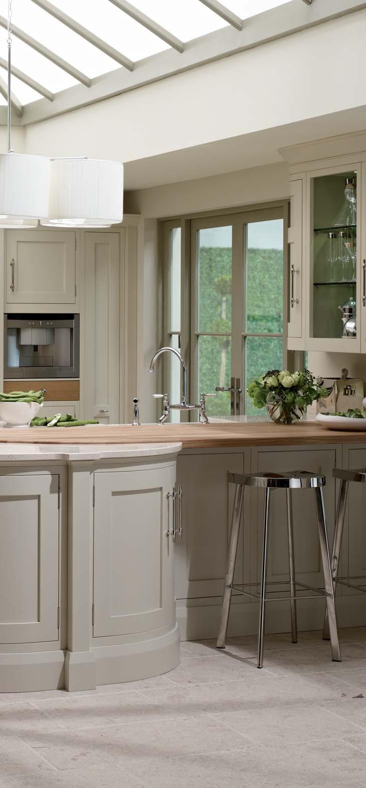 These in-frame Shaker cupboards are shown in Flint Grey and Almond, with solid brass handles and hinges in a bright nickel finish.