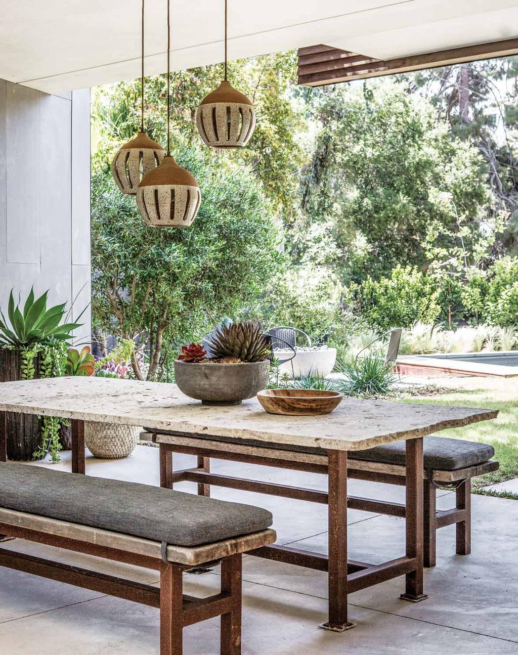 Opposite: In the outdoor dining space, which looks toward the pool deck, ceramic pendants by Heather Levine hang above a