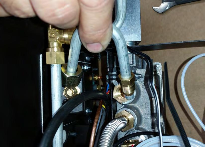 Remove the nozzle for the main burner by loosening the coupling and carefully pulling the pipe out and