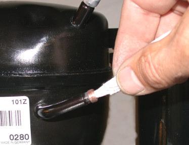 8. Use pliers to remove the aluminum cap and rubber plug on the remaining compressor suction tubing stub (the other top port on the compressor).