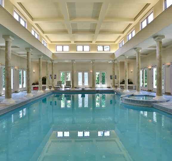 Indoor Swimming Pool The Indoor Swimming Pool area features a soaring beamed ceiling wrapped windows, natural stone slate, 15 sets of French entry doors opening out to various parts of the grounds