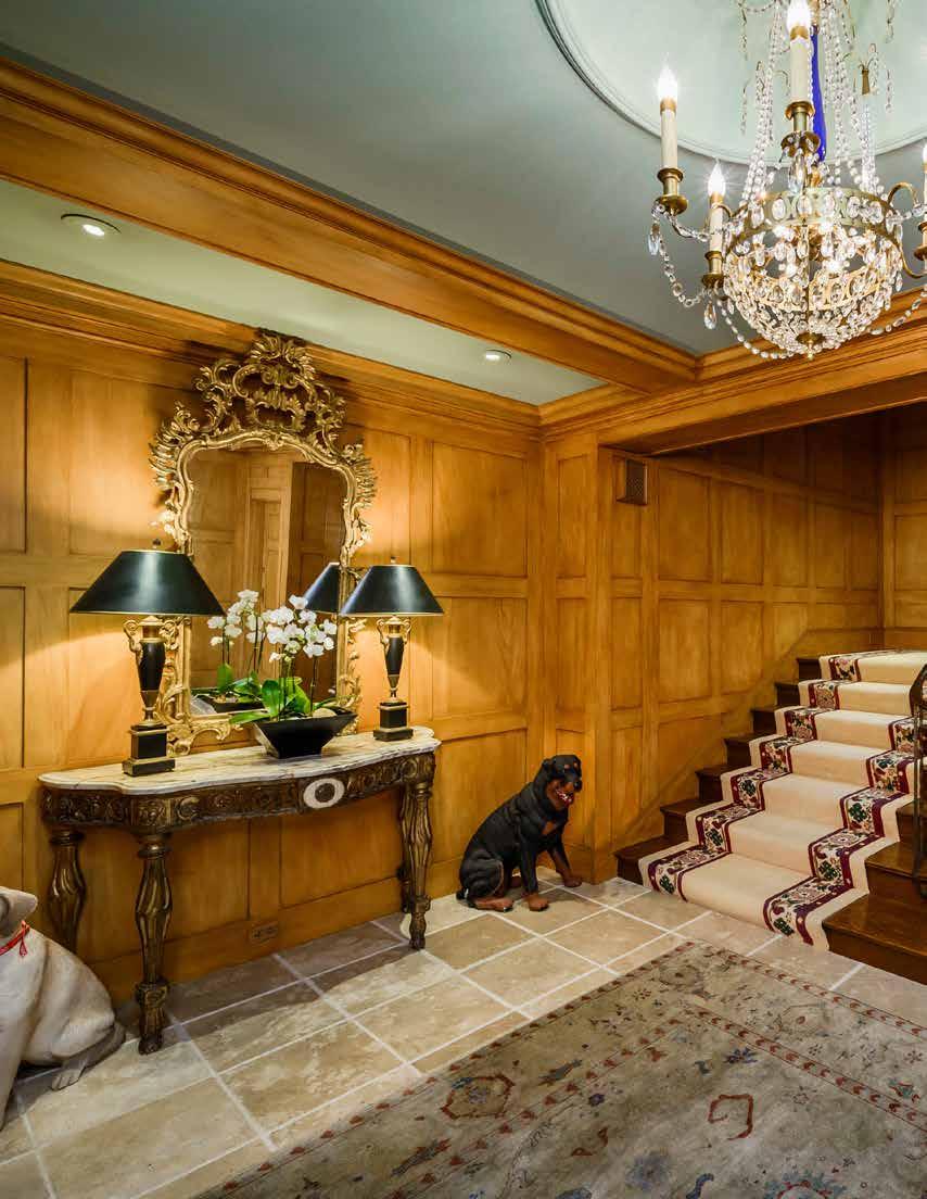 The inviting formal entry features tumbled marble floors, heated floors, beamed ceilings, exquisite wood paneled walls, recessed lighting, high