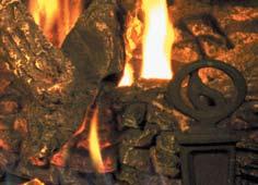 A Traditional cast andirons accent the realistic burn and glow of the detailed logs.
