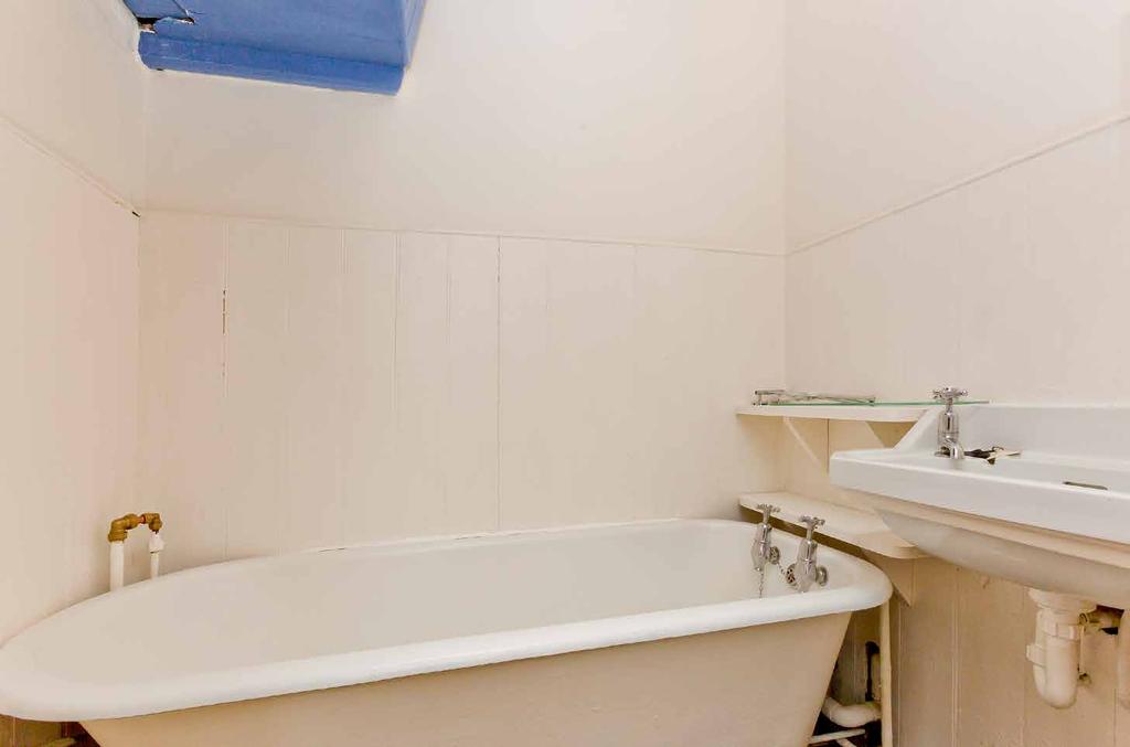 The two-piece bathroom is lined with tongueand-groove panelling and features a delightful 1930s roll-top bath and a