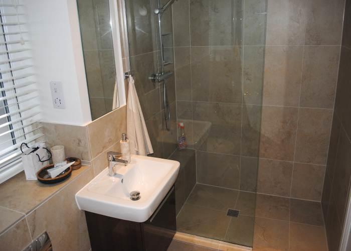 Wall mounted vanity wash hand basin with a high gloss Walnut cupboard under.