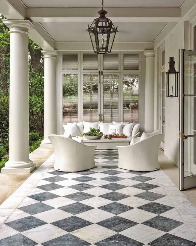 The home s porch is furnished with wing lounge chairs and a three-seater sofa from Janus et Cie.