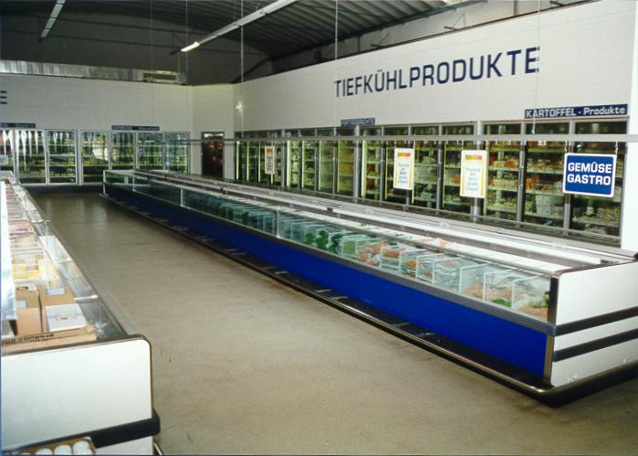 Sales room of a hypermarket glass doors for the deep-freeze cabinets with combined storage facilities and loading of the shelves from the back.